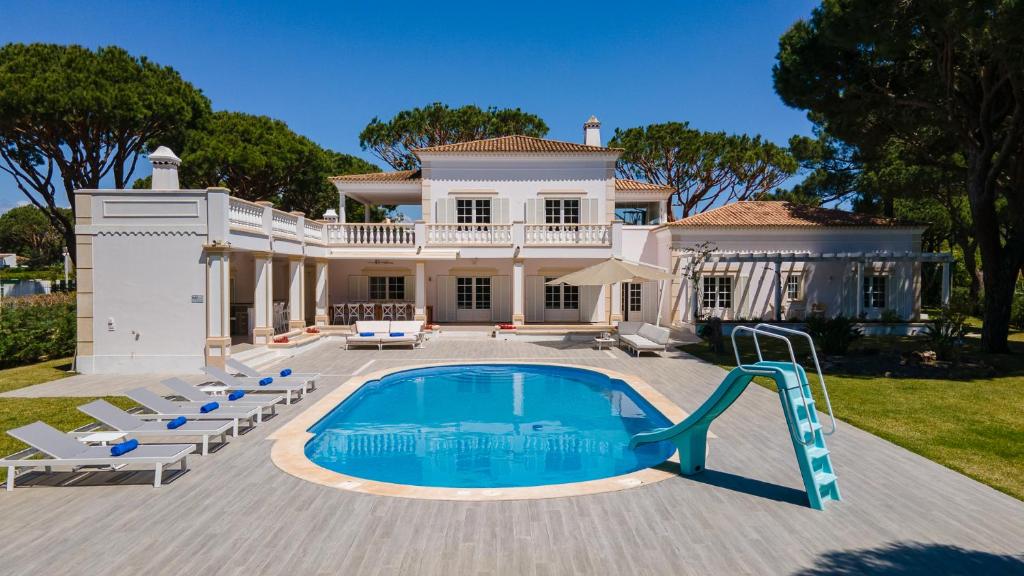 维拉摩拉Portuguese mansion close to marina, golf and beach.的一座大房子,在庭院里设有一个游泳池