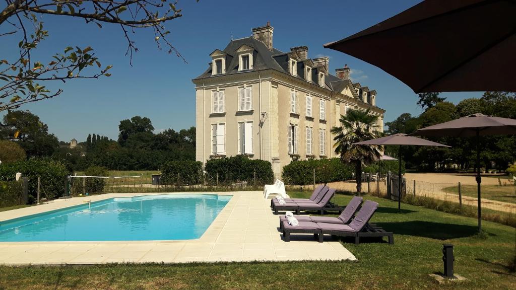 BrionChâteau La Mothaye - self catering apartments with pool in the Loire Valley的一座大型建筑,前面设有一个游泳池