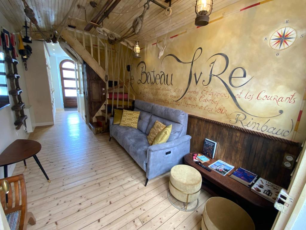 圣马洛Maison bord de mer « Le Bateau IvRe »的客厅设有蓝色沙发,靠墙写字
