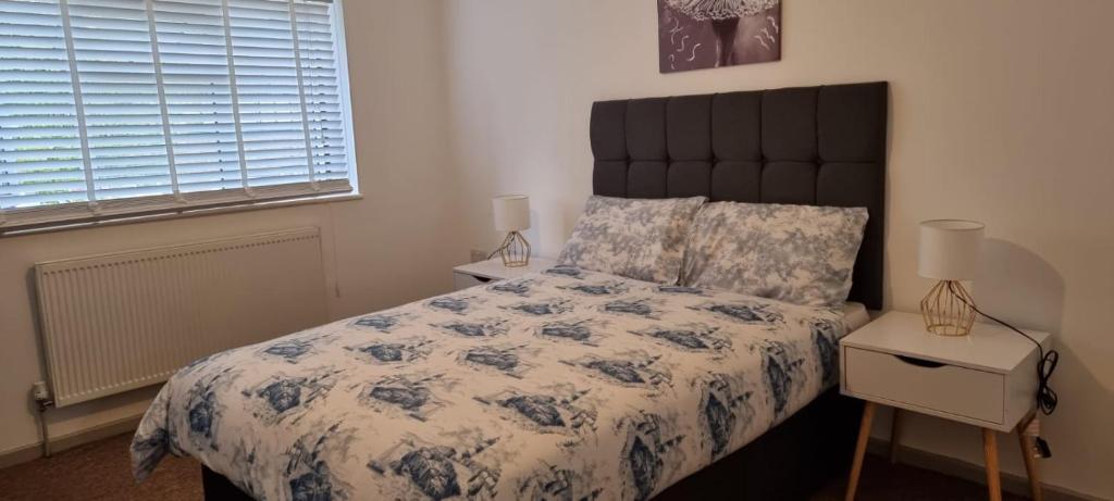 Thamesmead3 bed bedroom house with garden的一间卧室配有一张带蓝色和白色棉被的床