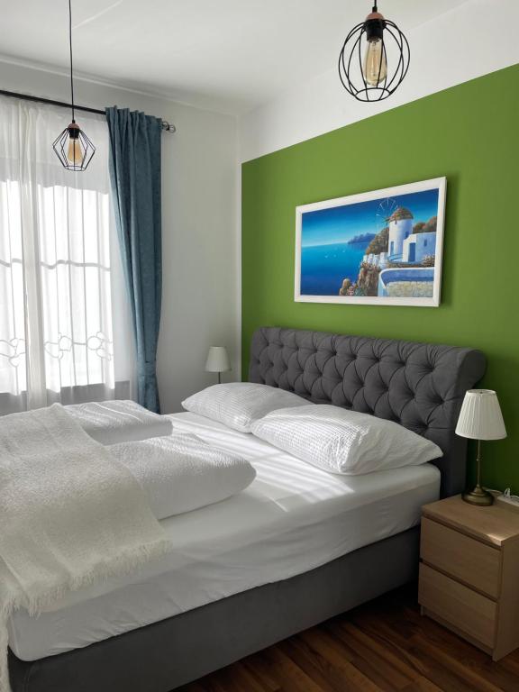 克拉根福Studios Klagenfurt的卧室配有白色大床和绿色墙壁