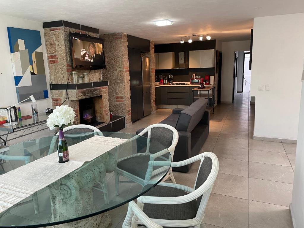 瓜达拉哈拉Alojamiento completo, con una excelente ubicación的用餐室以及带玻璃桌和椅子的厨房
