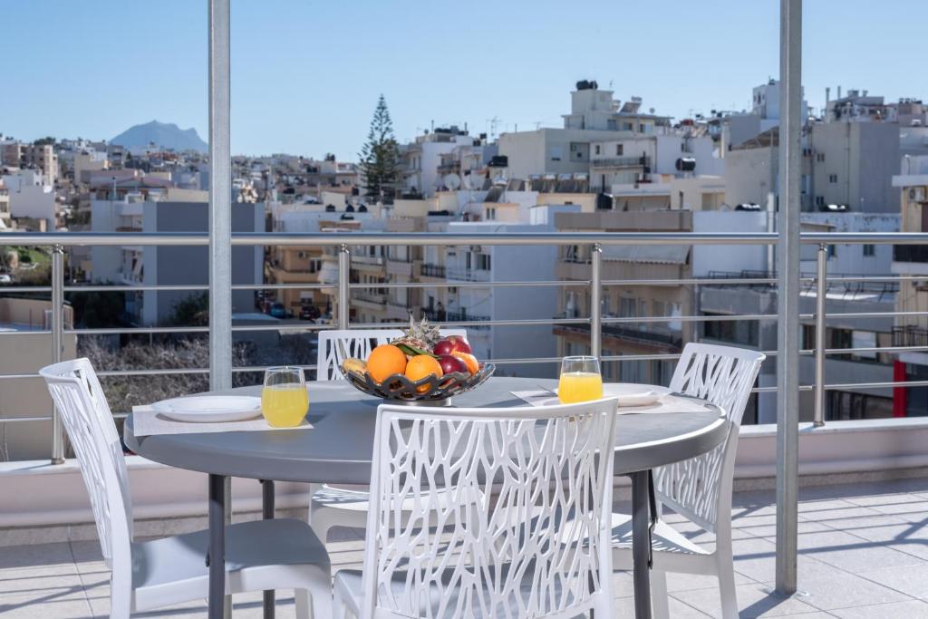 海若克利欧Rooftop Cosy Apartment Perfect Location的阳台上的桌椅和一碗水果