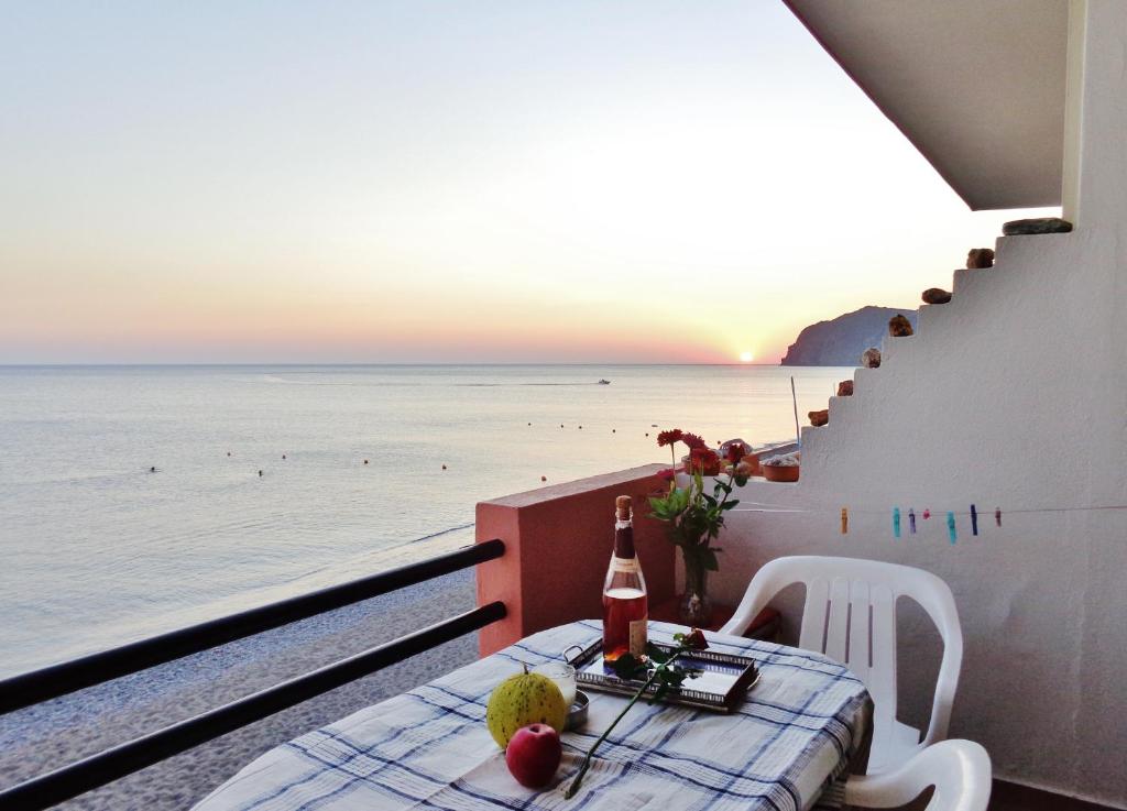 斯卡拉埃雷索Marilena的俯瞰大海的阳台的桌子和一瓶葡萄酒