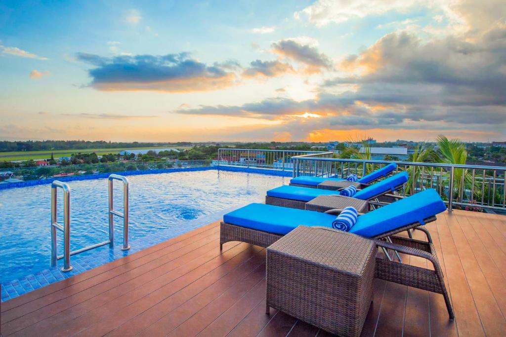 日惹Platinum Adisucipto Hotel & Conference Center的一个带蓝色躺椅的甲板和一个游泳池