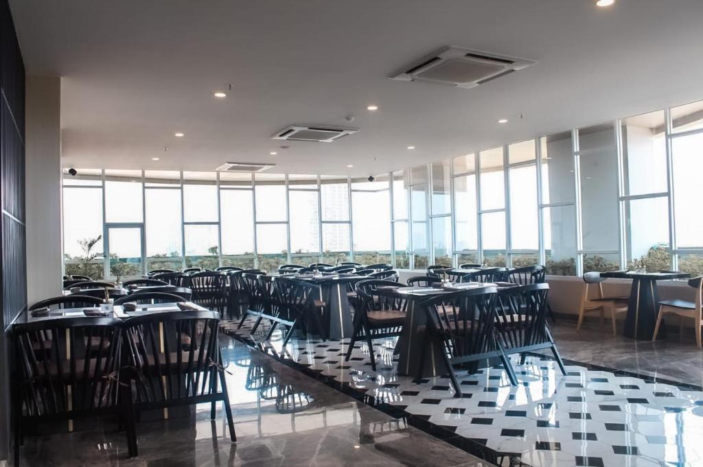 WonocoloBeSS Mansion Hotel Surabaya的用餐室设有桌椅和窗户。