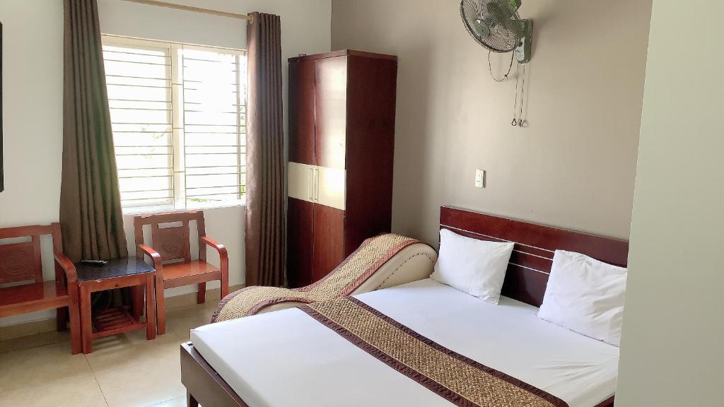 海防Motel TÂY HỒ的卧室配有床、椅子和窗户。