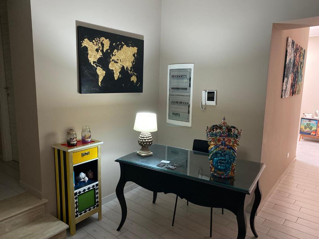 蒙雷亚莱Palazzo Liberty的一间设有一张桌子、一盏灯和一张墙上的地图的房间