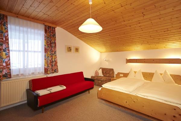 费尔兹姆斯Appartment Rettenwender的一间卧室配有一张大床和一张红色的沙发