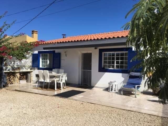 西尔韦斯Quinta Vale de Luz的蓝色和白色的房子,配有桌子和椅子