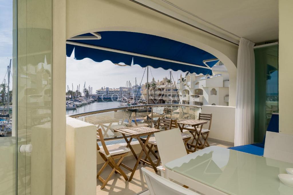贝纳尔马德纳Benalmadena Costa Sol Holiday Rentals的阳台配有桌椅和码头