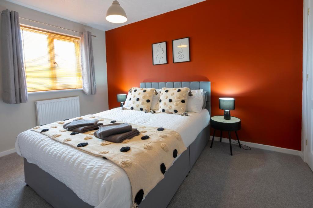 斯塔福德Bright & modern 4 bedroom townhouse的一间卧室配有一张带橙色墙壁的大床