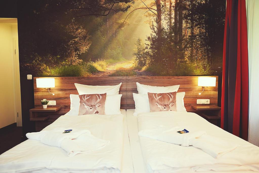 哈嫩克利博克斯维斯Hotel Mein Bergblick的一张带白色床单和枕头的床铺,配有绘画作品