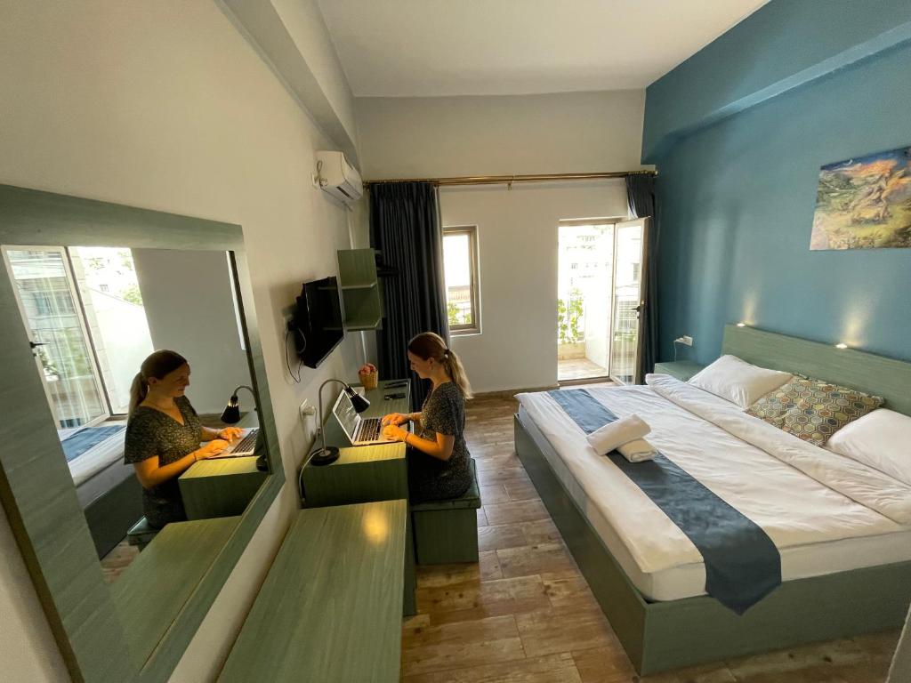 安曼The Sydney Hotel的两间女性入住带一张床和镜子的酒店客房