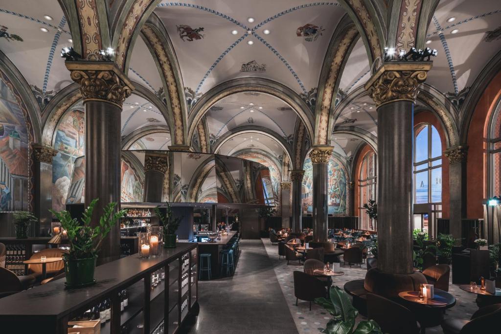 卑尔根卑尔根证券交易所酒店的餐厅拥有华丽的天花板和桌椅