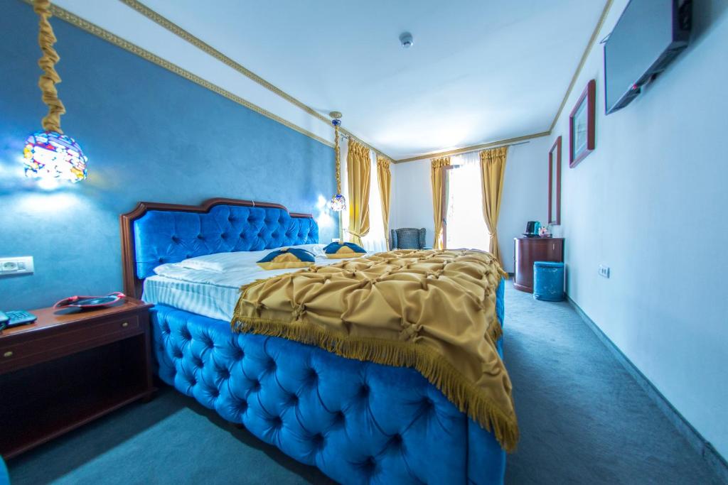 普雷代亚尔Voila Inn Predeal的蓝色卧室,配有一张蓝色床头板的床