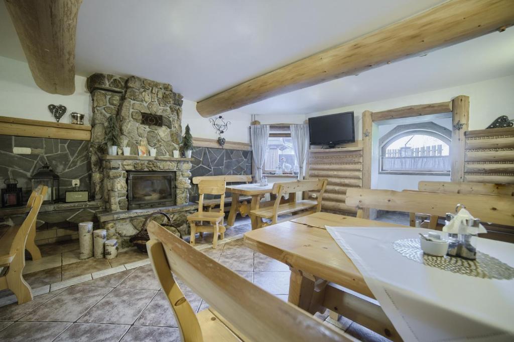 布科维纳-塔钱斯卡Willa Bartuś Baliczek的客厅设有木桌和石制壁炉。