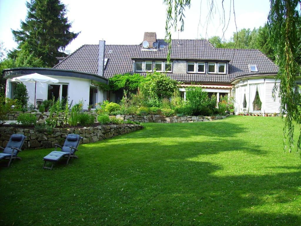 代斯特尔山麓巴德明德尔Gästehaus Villa Kreativ Susanne Lay的草上带两把椅子的院子的房子