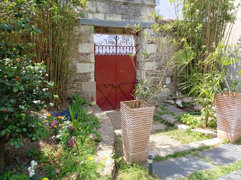 南特Le pigeonnier de la plume的花园里有种植物的红色门