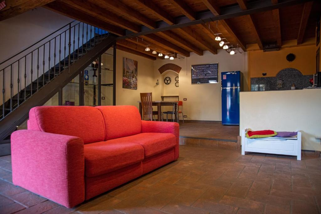 米兰大阿尔扎亚卡萨多尔斯公寓的一间带红色沙发的客厅和楼梯