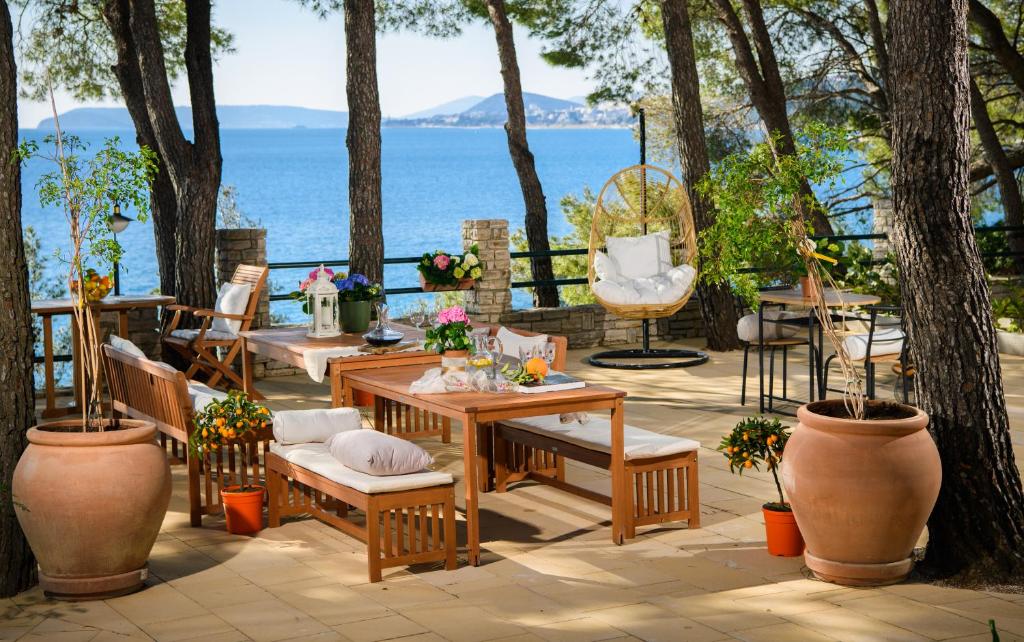 珀德垂那Lavica Bellevue apartments & studios的一个带桌椅的庭院和大海