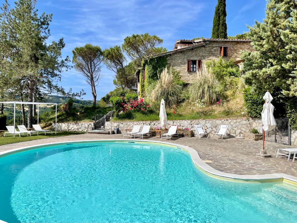 古比奥La Panoramica Gubbio - Maison de Charme - Casette e appartamenti self catering per vacanze meravigliose!的房屋前的游泳池