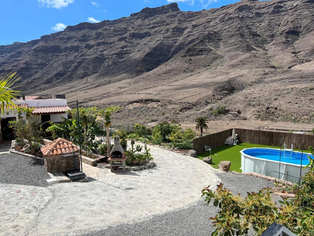 莫甘Casa rural con baño adaptado y piscina en Mogán的后院设有游泳池和山脉