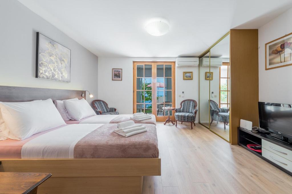 杜布罗夫尼克Sunshine Place Apartments的一间卧室配有一张床和一台平面电视