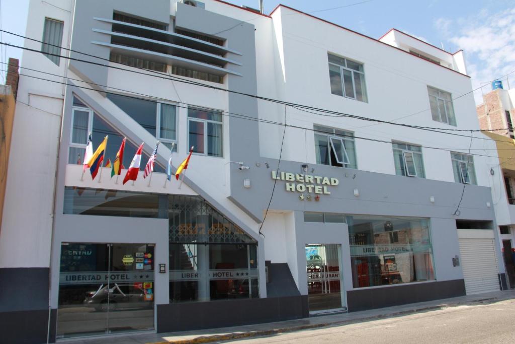 特鲁希略Libertad Hotel的大楼前有旗帜的酒店