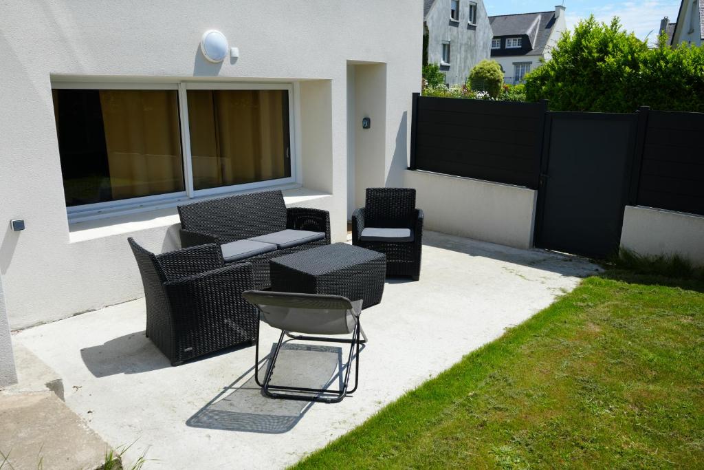 BoharsNouveau - studio aux portes de Brest的一个带沙发和椅子的庭院和一个围栏
