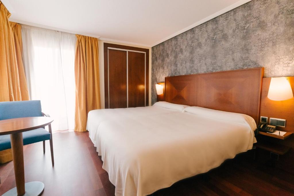 阿尔么丽亚托雷鲁兹中心酒店的酒店客房,配有床、桌子和椅子
