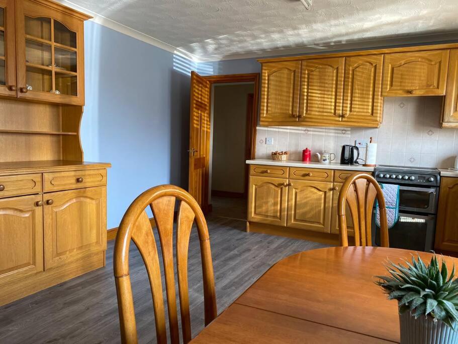 格雷特纳Gretna Getaway的厨房配有木制橱柜和桌椅