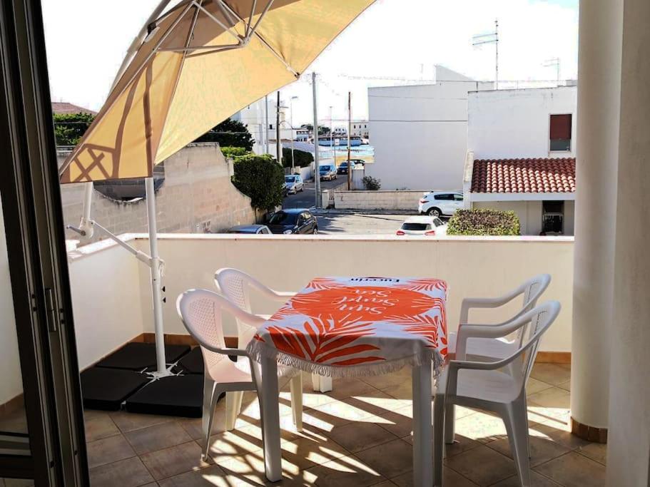 托雷桑塔萨宾娜At home on the coast的阳台配有桌椅和遮阳伞
