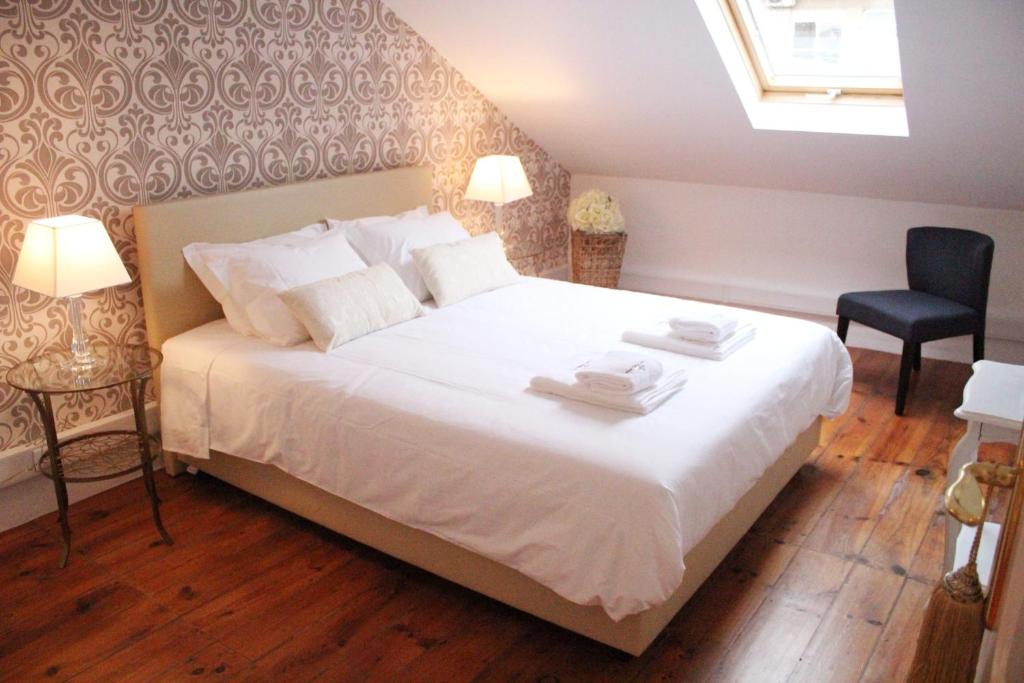 里斯本天空阁楼里斯本宾馆的卧室配有一张白色大床和一把椅子