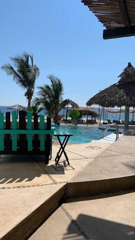 CoyucaCondominio Agave del Mar的海滩游泳池旁的绿色长凳