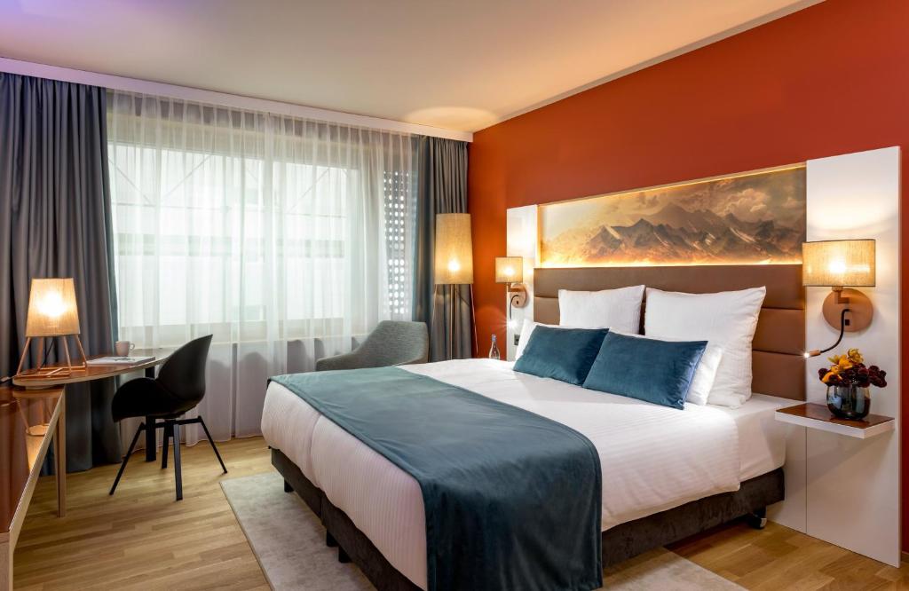 克洛滕Leonardo Hotel Zurich Airport的配有一张床和一张书桌的酒店客房