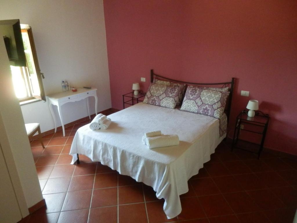 丘西Il casale di Sandra的一间卧室设有一张床和红色的墙壁