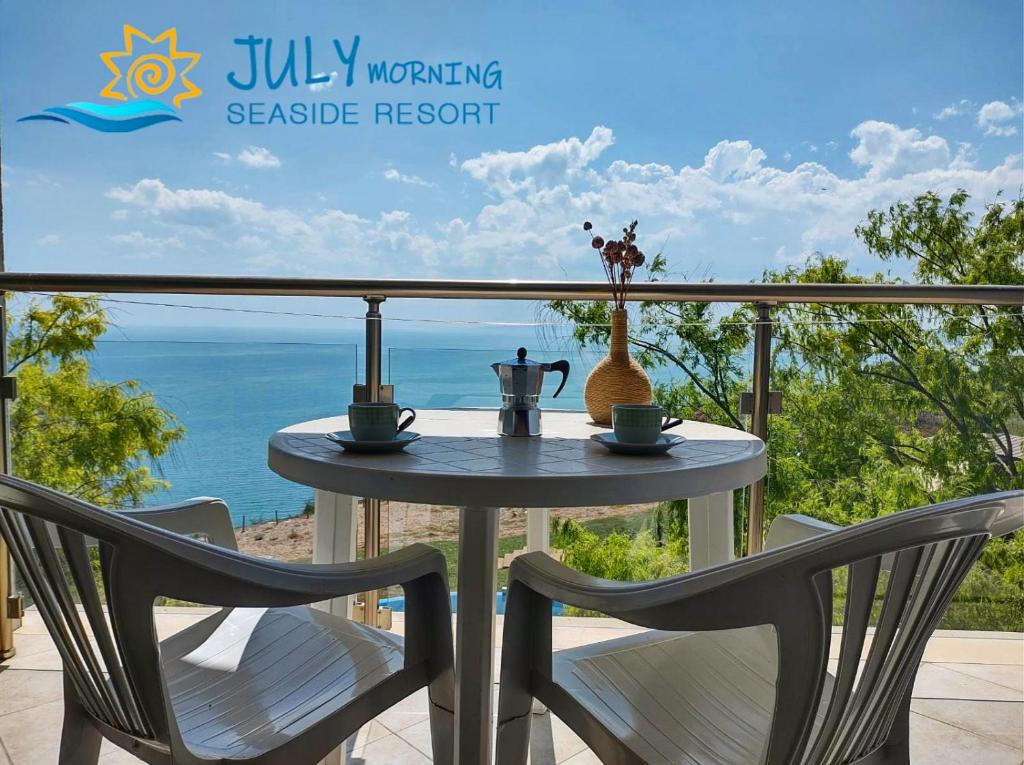 卡瓦尔纳七月清晨海边度假酒店的阳台配有一张桌子和两把椅子,享有海景