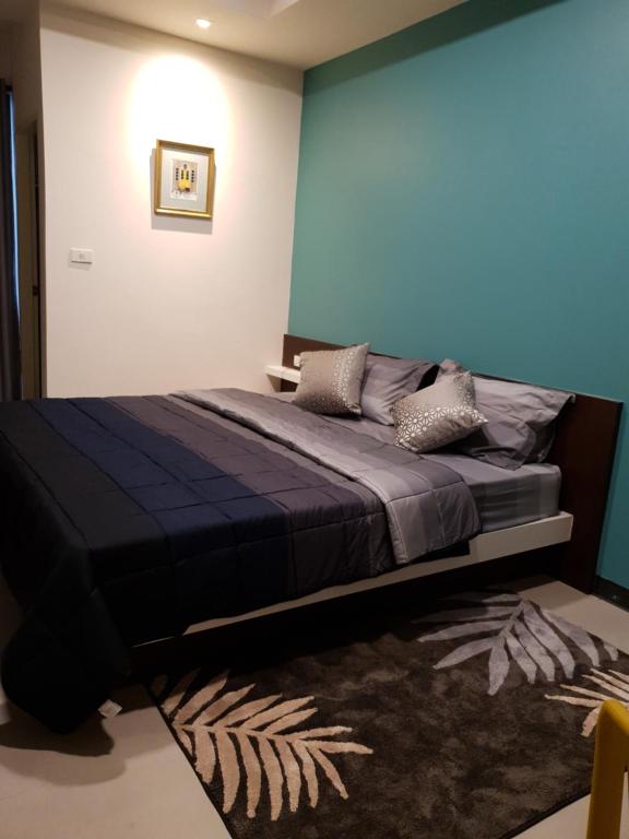 曼谷552 Residence的一间卧室配有一张蓝色墙壁的床