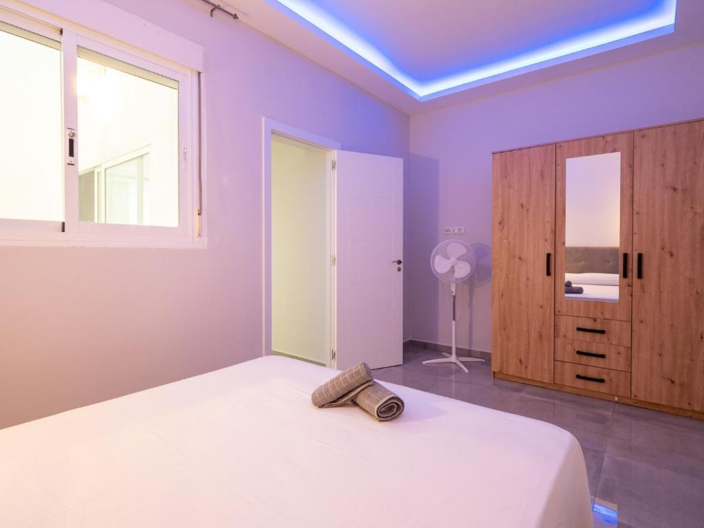 福恩吉罗拉Luxury Suite Fuengirola 1的卧室设有紫色墙壁、床和窗户