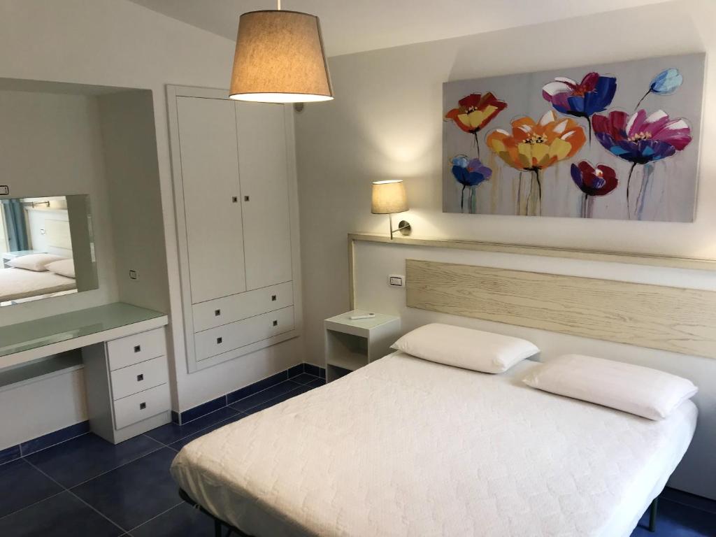 马拉泰亚2 bedrooms house at Maratea 50 m away from the beach with sea view enclosed garden and wifi的卧室配有白色的床和镜子