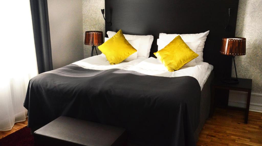 卡尔斯塔德广场克拉丽奥酒店的一张大床,上面有两个黄色枕头