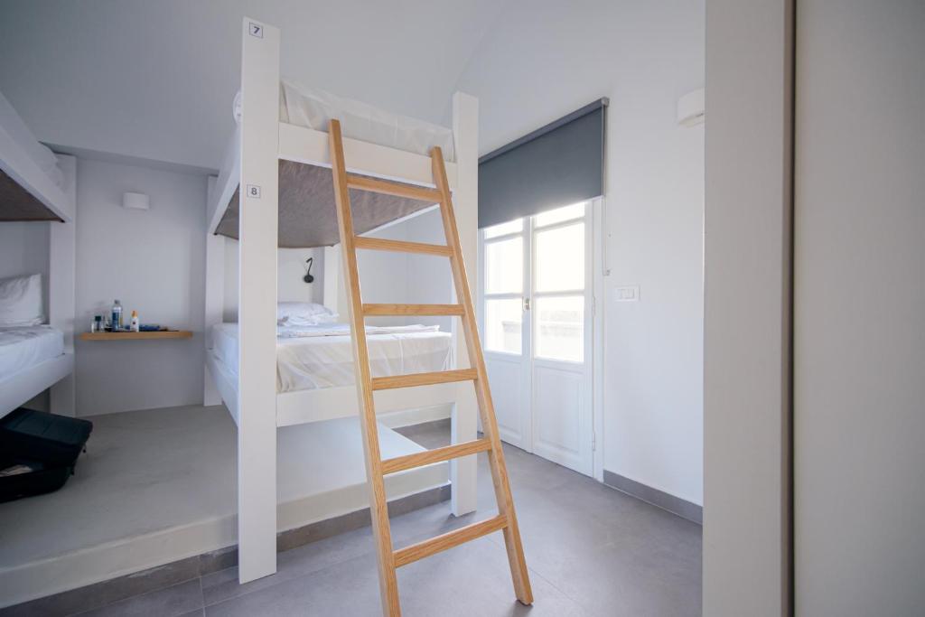 伊亚Central Hostel Oia的配有梯子的小客房内的双层床