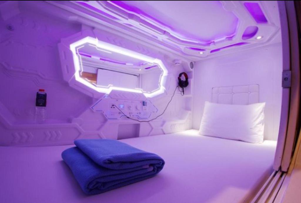 雅加达Super OYO 91328 Fiducia Capsule Hotel的小房间,设有一张床和一盏灯