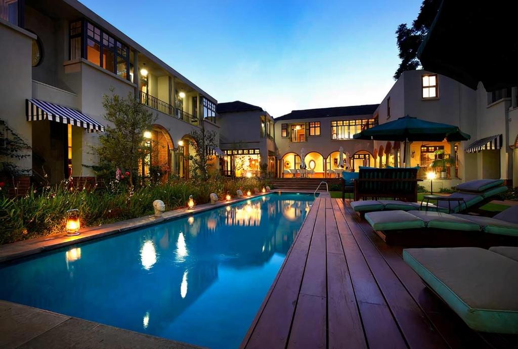 约翰内斯堡温斯顿酒店 的一座带躺椅的游泳池和一座建筑