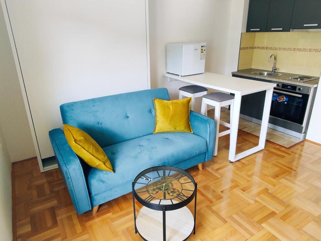 普卢日内Apartment Lake story的客厅配有一张蓝色的沙发,配有一张桌子