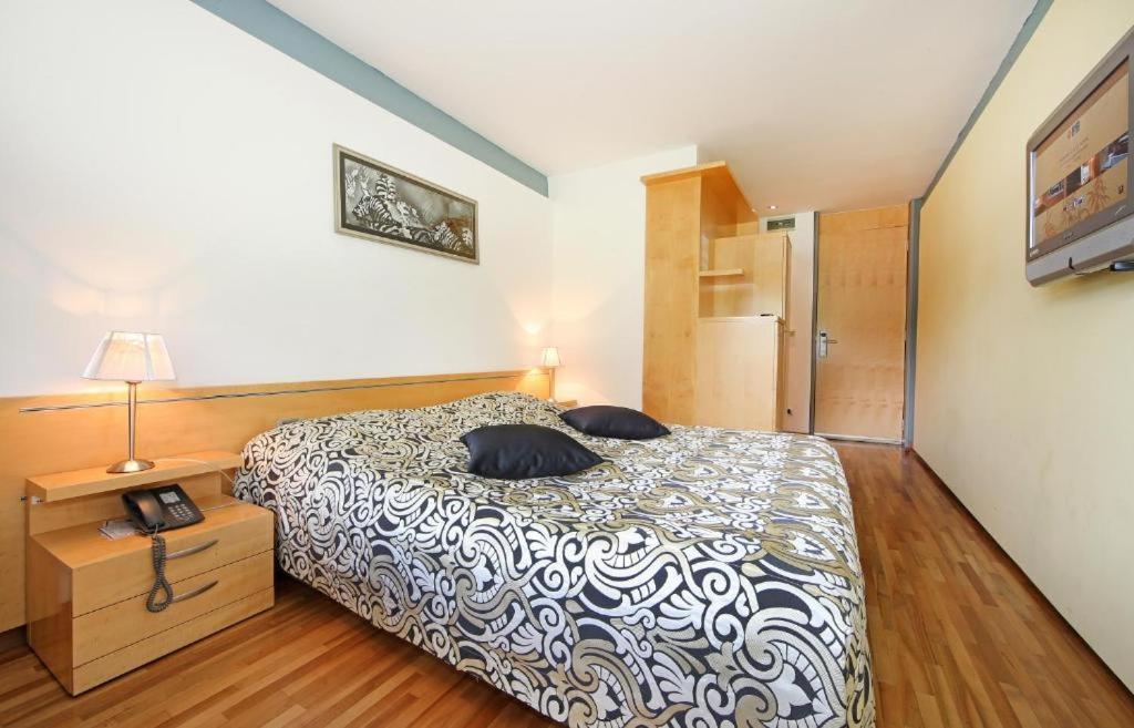 格罗苏普列Hotel Grosuplje的一间卧室配有一张带两个枕头的床