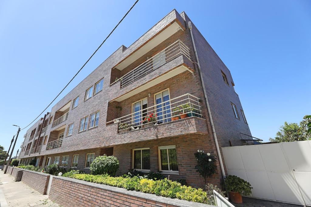 加亚新城FLH Gaia Valadares Comfy Apartment的一座砖砌建筑,设有阳台,种植了植物