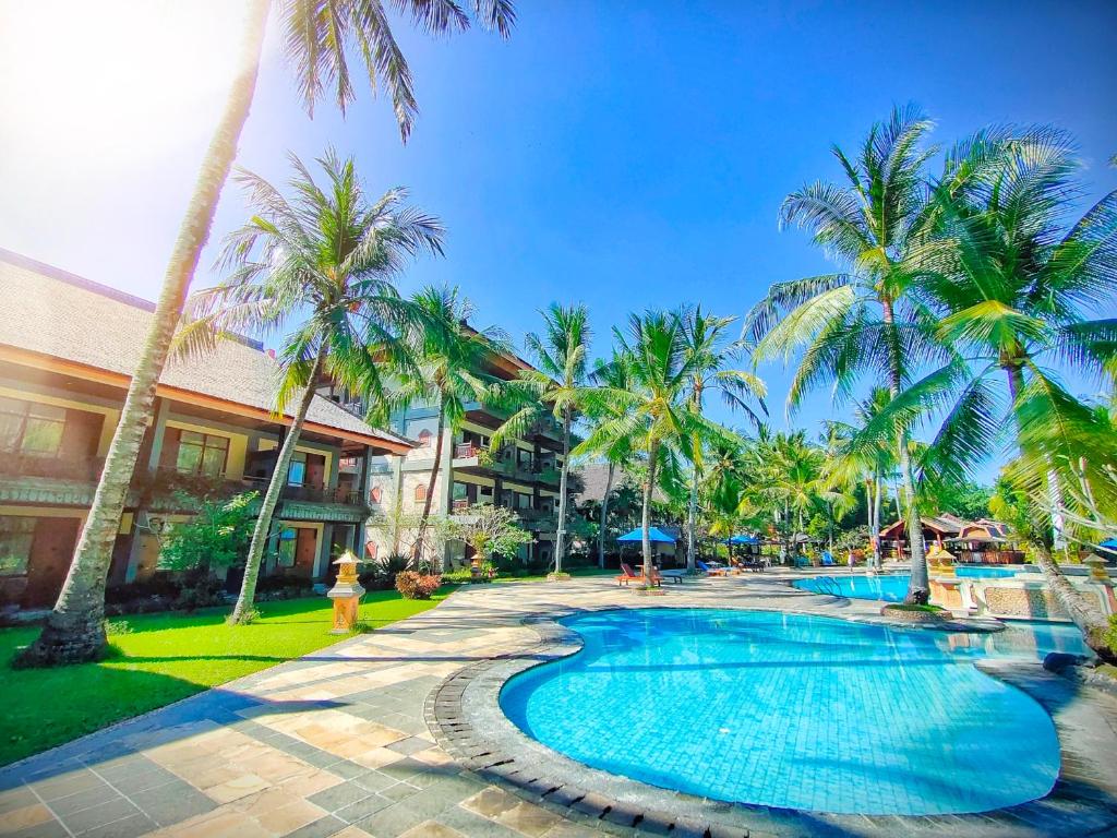 圣吉吉龙目岛嘉雅卡塔酒店的棕榈树和消防栓的度假游泳池
