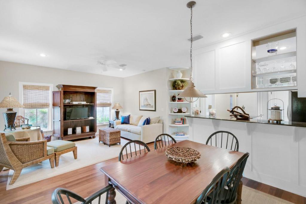 因莱特海滩Magnolia Cottage的厨房以及带木桌和椅子的客厅。